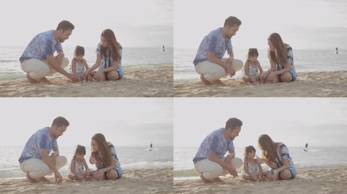 亚洲家庭和她的女儿在海滩上穿着连衣裙扎染。