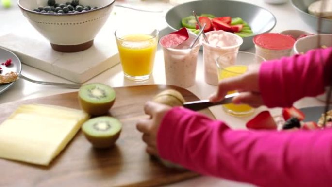 健康，绿色和新鲜的猕猴桃，用手在夏季准备沙拉，小吃或餐点。节食的妇女将水果切成或切成有机果汁，以维持