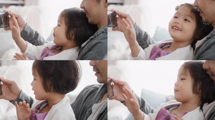 亚洲父亲和孩子使用智能手机进行视频聊天小女孩挥舞着分享周末与爸爸享受手机与朋友4k聊天