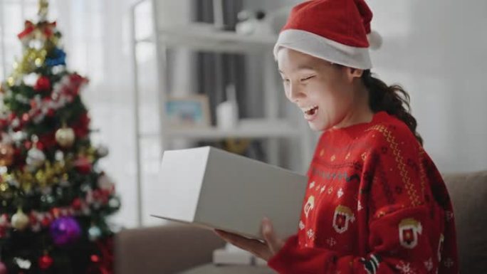 亚洲女性在圣诞节打开礼品盒