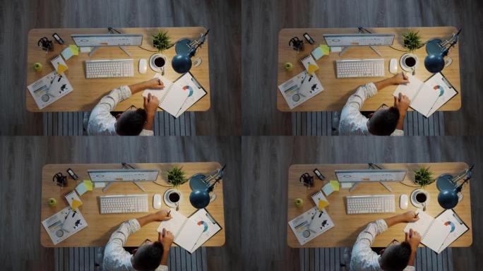 在办公室桌子上工作的商人的高角度视图笔记本电脑屏幕上的书写