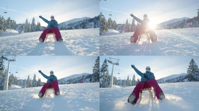 低角度快乐的女人雪橇在空旷的滑雪场斜坡上因covid19而关闭