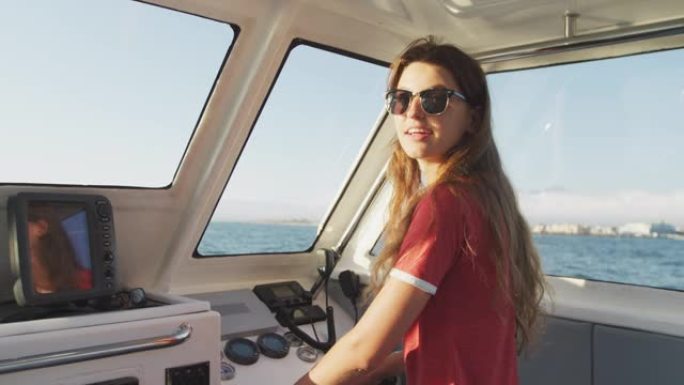 一个十几岁的高加索女孩开着船看着相机的侧视图