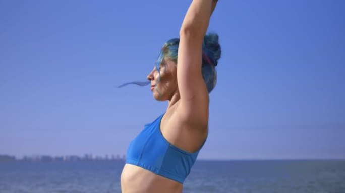一位年轻漂亮的运动女子，有着绿松石般的头发，正在做瑜伽练习，