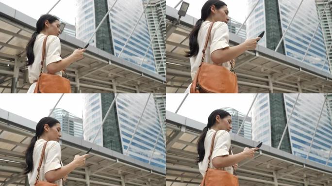 亚洲妇女在城市的街道上使用手机