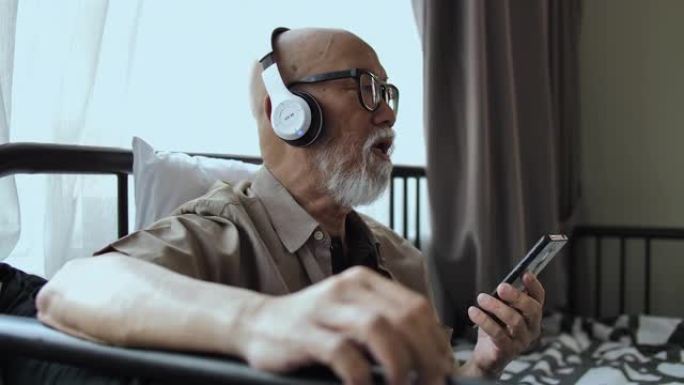 老人在家用耳机听音乐