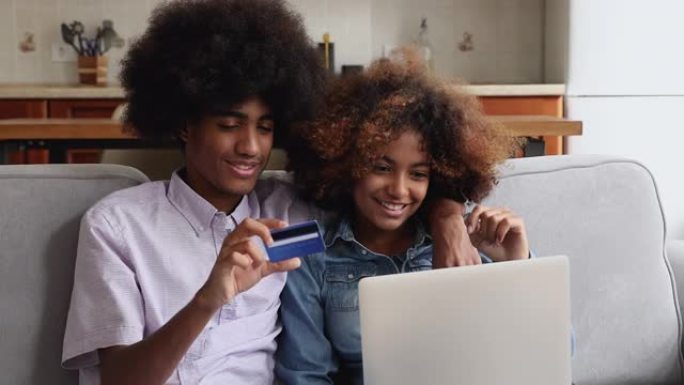 非洲青少年夫妇在线购买使用笔记本电脑和借记卡