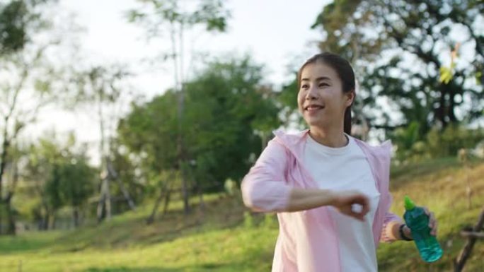 年轻的亚洲女子在公园运动前热身，运动和锻炼