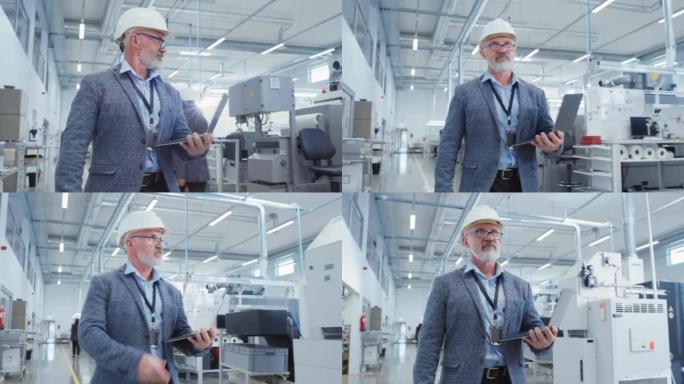 一位留着胡子的中年总经理在工厂里行走，穿着休闲服和一顶白色安全帽的肖像。从事笔记本电脑工作的重工业专