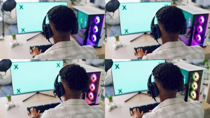 使用霓虹灯键盘和有线鼠标色度键在计算机上玩视频游戏的游戏玩家。一个戴着带麦克风的游戏耳机的小男孩正忙