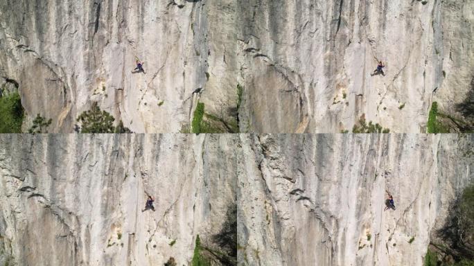 无人机: 女性登山者学习绳索在自然墙中寻找。
