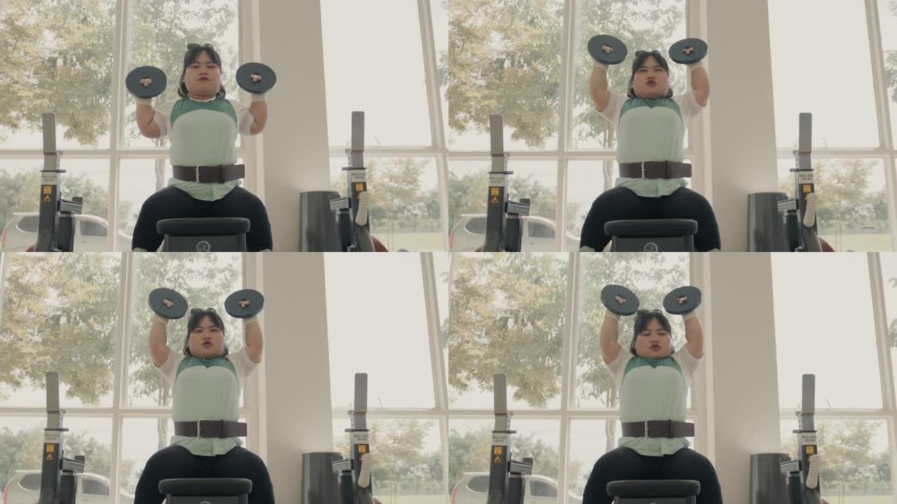 残疾女性在健身房用哑铃和举起哑铃锻炼。