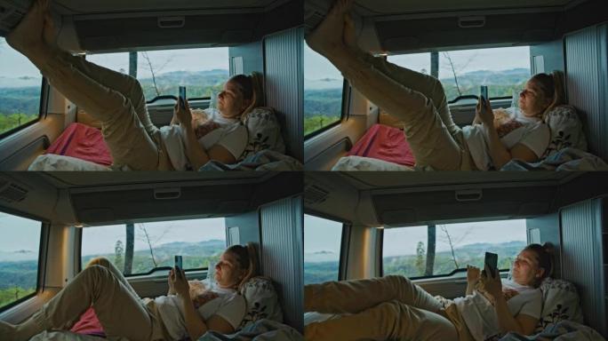 金发碧眼的女人正躺在她的面包车里，伸着腿，用她的智能手机