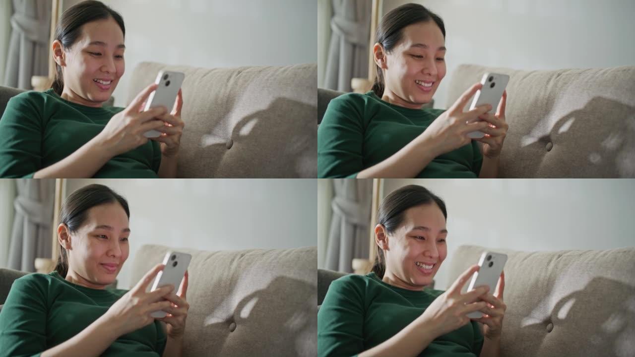 亚洲女性在沙发上使用智能手机