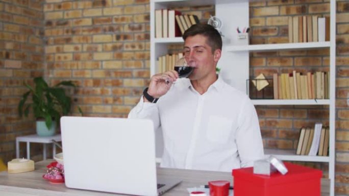 白人男子使用笔记本电脑喝一杯酒和聊天进行视频通话