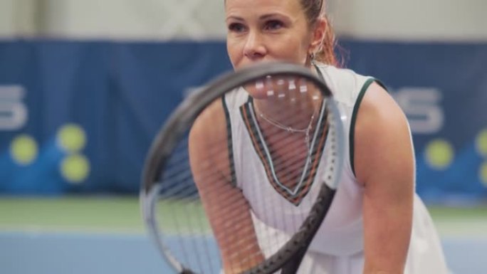 女子网球运动员在锦标赛期间手持球拍的Potrait，准备接受击球。自信的竞技职业女运动员。体育回放。