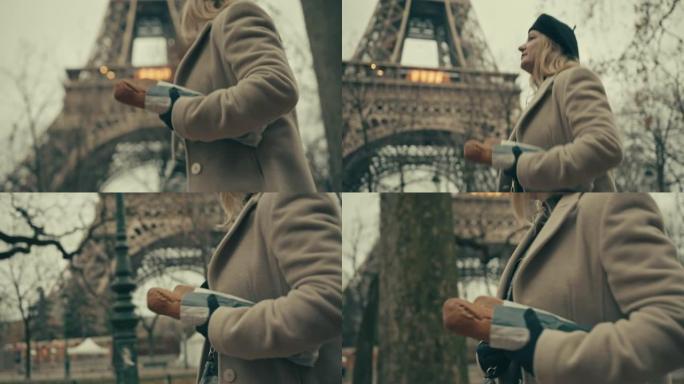 SLO MO时尚的法国女人沿着埃菲尔铁塔背着法式长棍面包