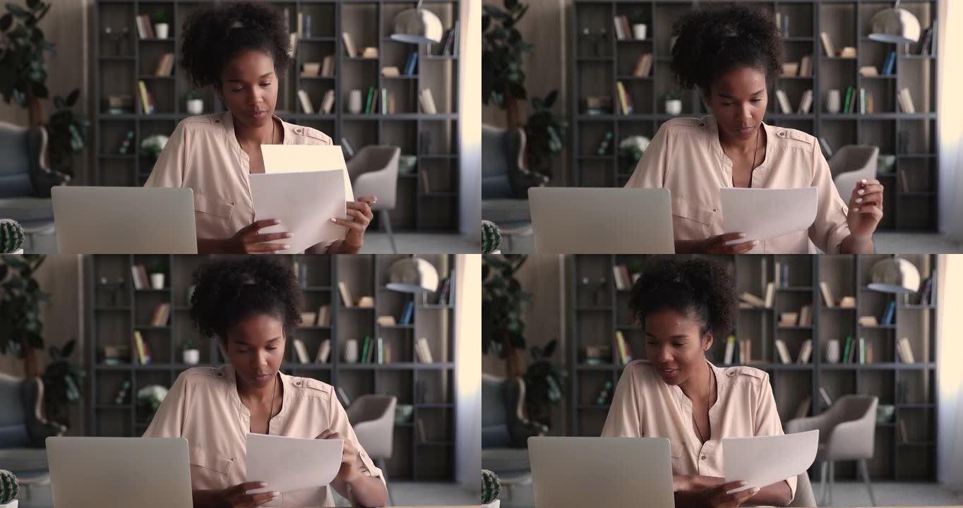 年轻的非洲裔美国商务小姐处理纸质文件。