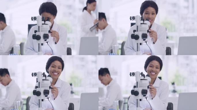 科学家在实验室使用显微镜分析医学样本的画像。快乐的黑人妇女微笑着做实验，开发一种治疗方法。微生物学家