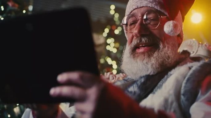 带平板电脑的快乐圣诞老人