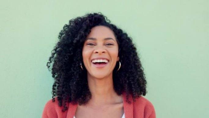 绿色墙壁背景上的微笑、大笑和快乐的黑人女性。滑稽、年轻和喜剧的年轻女性肖像脸，自然的非洲头发，生活的