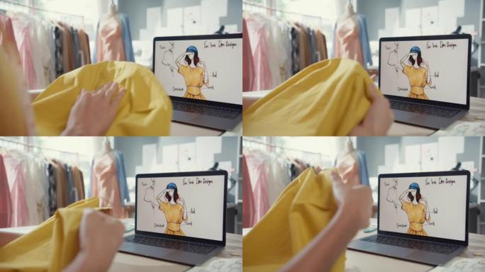 特写年轻的亚洲女士裁缝与笔记本电脑在图形素描照片使用卷尺织物比较样品在商店的桌子上创建服装设计新系列