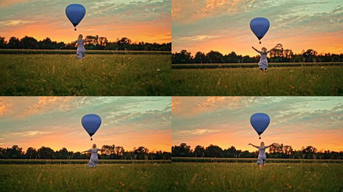 时间扭曲效应女人在草地上奔跑，向飞舞的热气球挥手