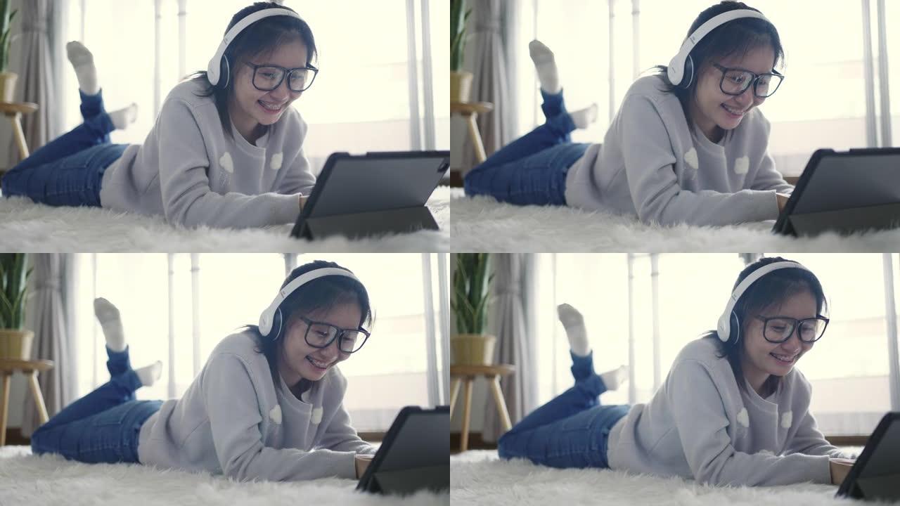 年轻女子在数字平板电脑和耳机上放松音乐