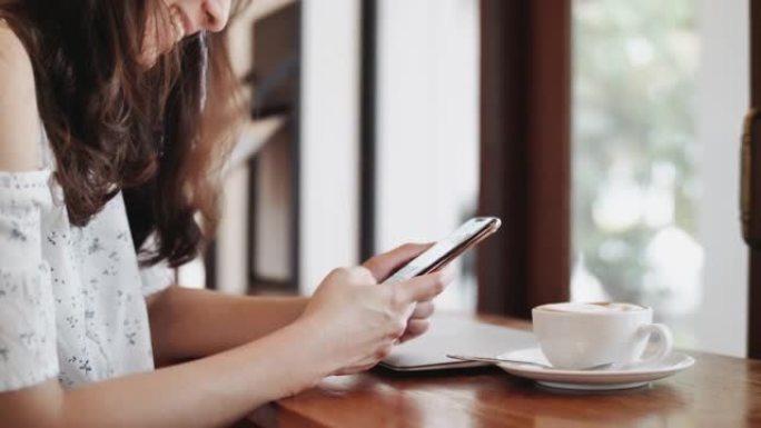 咖啡馆里使用智能手机的女人
