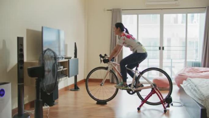 亚洲运动女子在家健身自行车