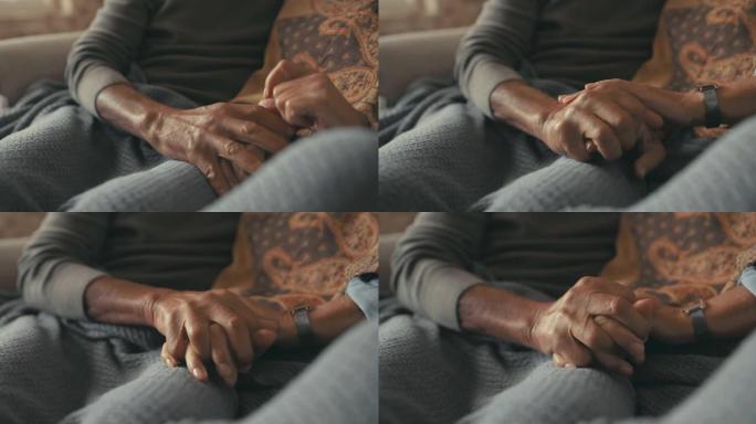 4k视频片段，一对无法识别的夫妇坐在家里的沙发上手牵手