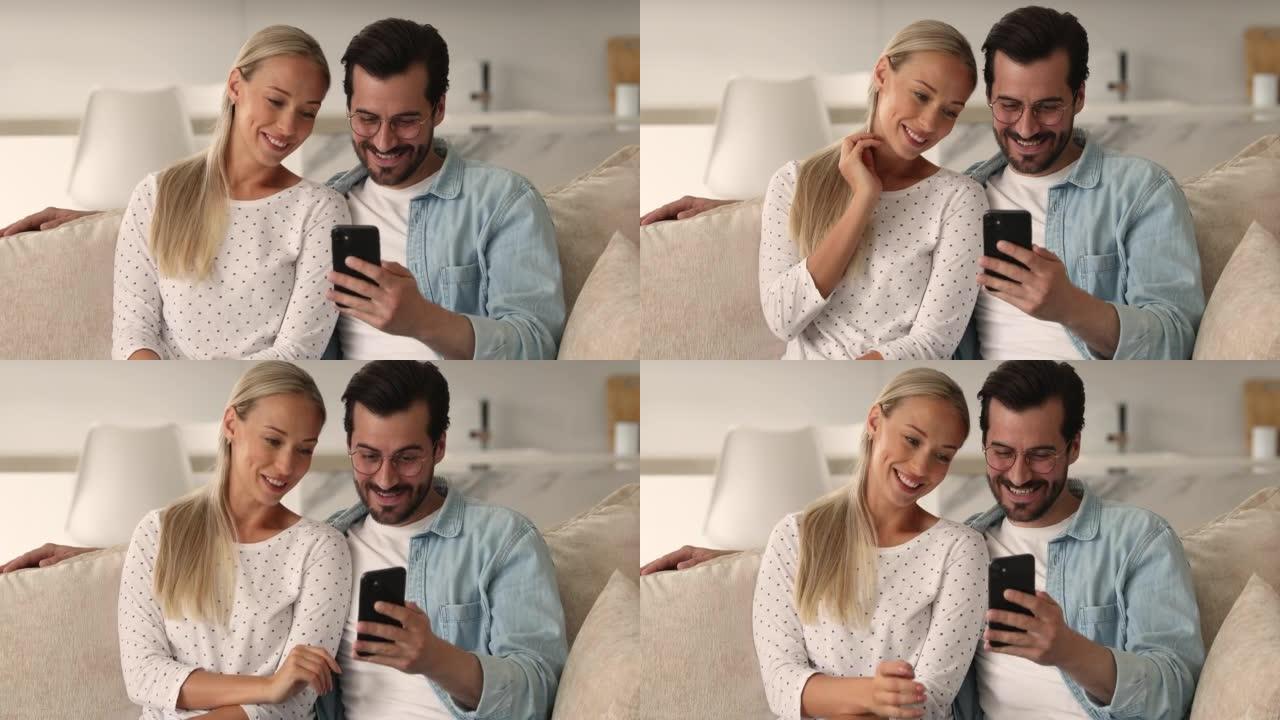 使用手机应用程序快乐地结合真诚的年轻家庭夫妇。