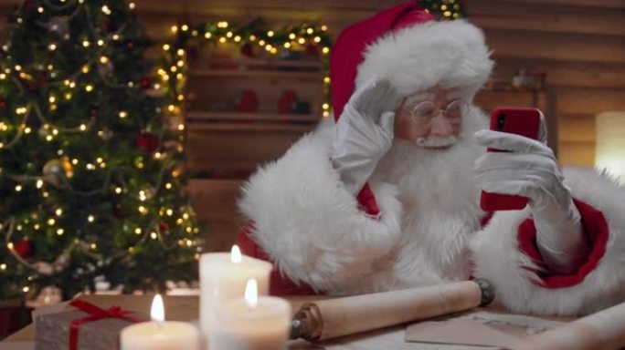 圣诞老人与他在智能手机上进行视频聊天的人说再见