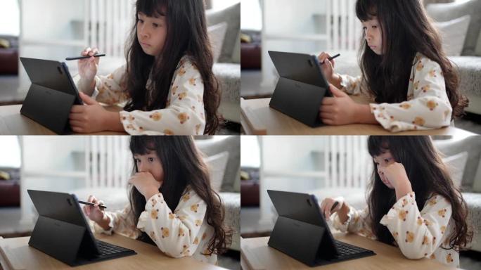 小女孩在家在数字平板电脑上画画