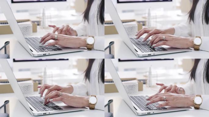 在现代办公室中使用笔记本电脑的无法识别的女商人的4k视频片段