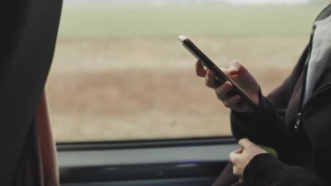 青少年在乘坐公共汽车时在智能手机上滚动的手