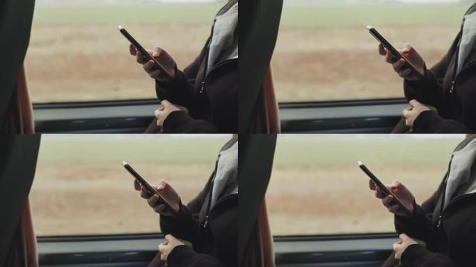 青少年在乘坐公共汽车时在智能手机上滚动的手