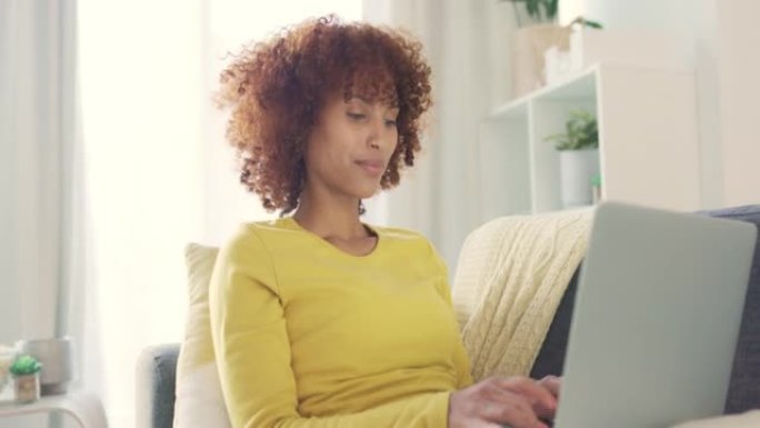 一名黑人妇女在家里用笔记本电脑远程工作的肖像。快乐的学生在做研究和计划的同时微笑着浏览互联网。自信的