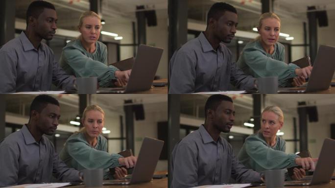 使用笔记本电脑和平板电脑在工作中讨论的男女商业同事