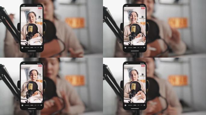 亚洲女性影响者使用麦克风佩戴耳机在线社交媒体用智能手机录制内容