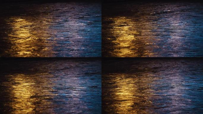 平静的河水，彩色路灯在夜间反射