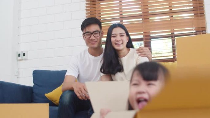 韩国妈妈、爸爸和女儿一起在新家拆包时玩耍，搬入搬迁后坐在地板上，箱子放在一起。