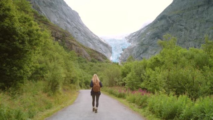 4k视频片段，一个无法识别的女人探索Briksdal冰川的山脉