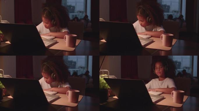 一个女孩正坐在家里专心地在线学习，记下她通过平板电脑学到的知识。由于Covid 19，人们无法外出生
