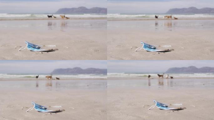 一个面具躺在沙滩上的沙滩上，背景是波浪