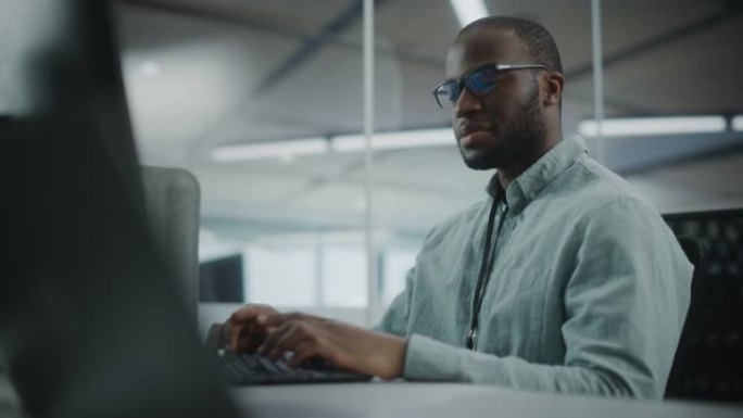 真正的办公室: 在台式电脑上工作的专业黑色IT程序员。男性网站开发人员和软件工程师开发应用程序，视频