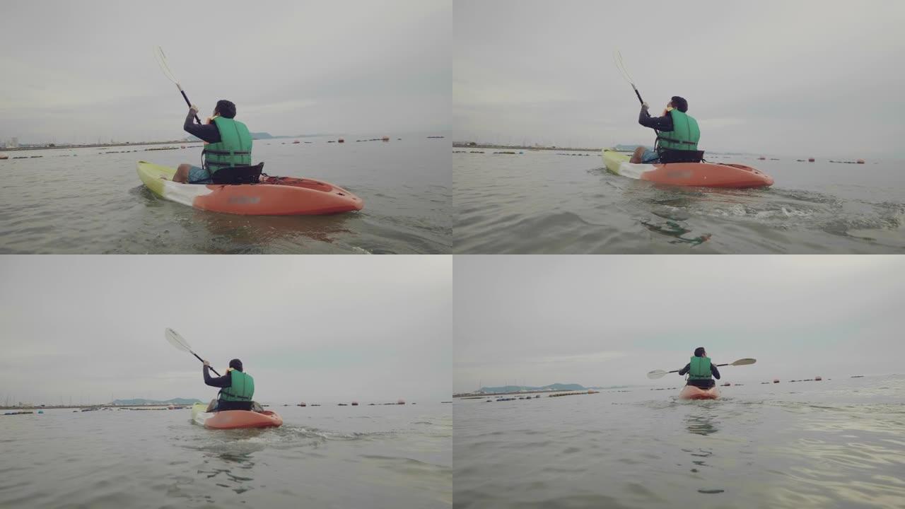 极限运动: 亚洲男性周末在海上划皮艇。