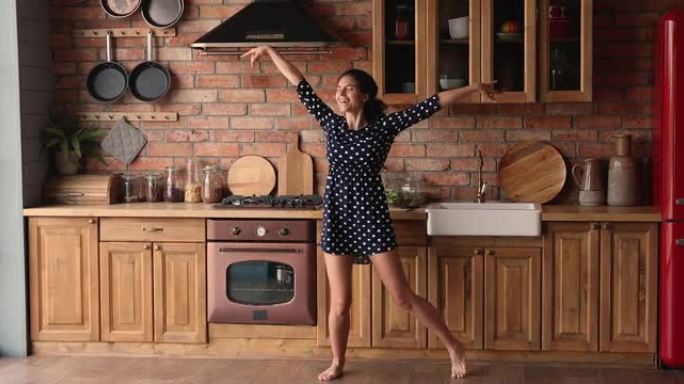 精力充沛快乐的年轻西班牙裔美女在厨房跳舞。