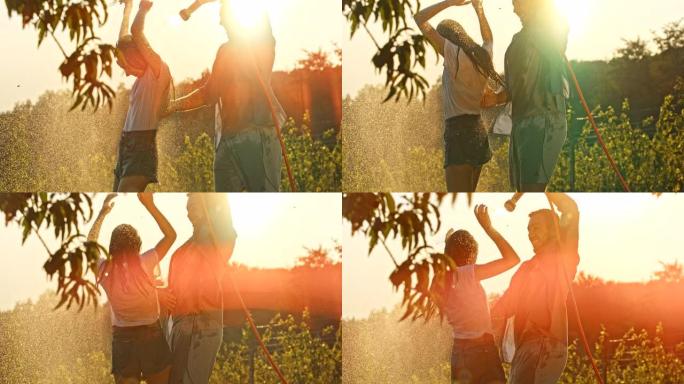 超级SLO MO年轻人玩得开心，用花园软管里的水喷洒他的女朋友