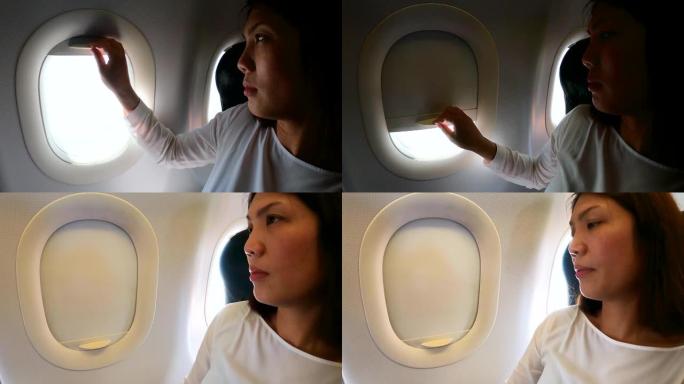 女乘客关闭飞机窗户休息